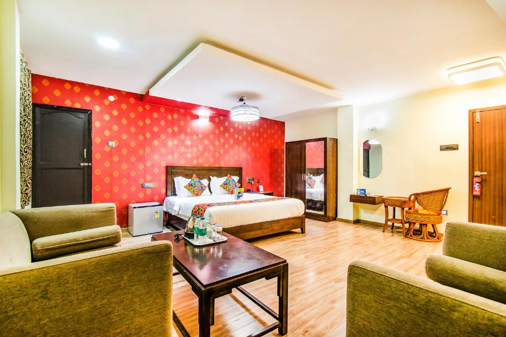 a hotel room with a bed and a living room at FabHotel Prince Park Vellore in Vellore