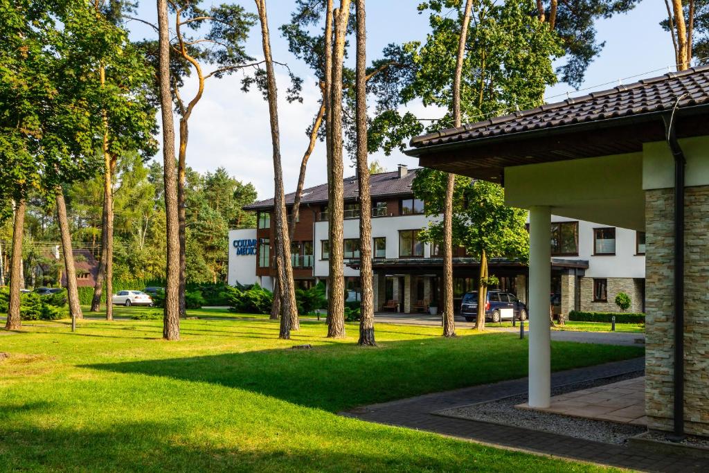 a building with palm trees in front of a yard at Columna Medica in Łask