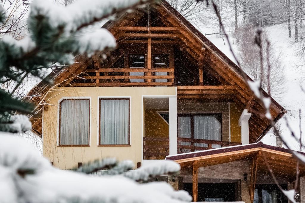 a log cabin in the snow at Pensiunea Dor de munte in Bran