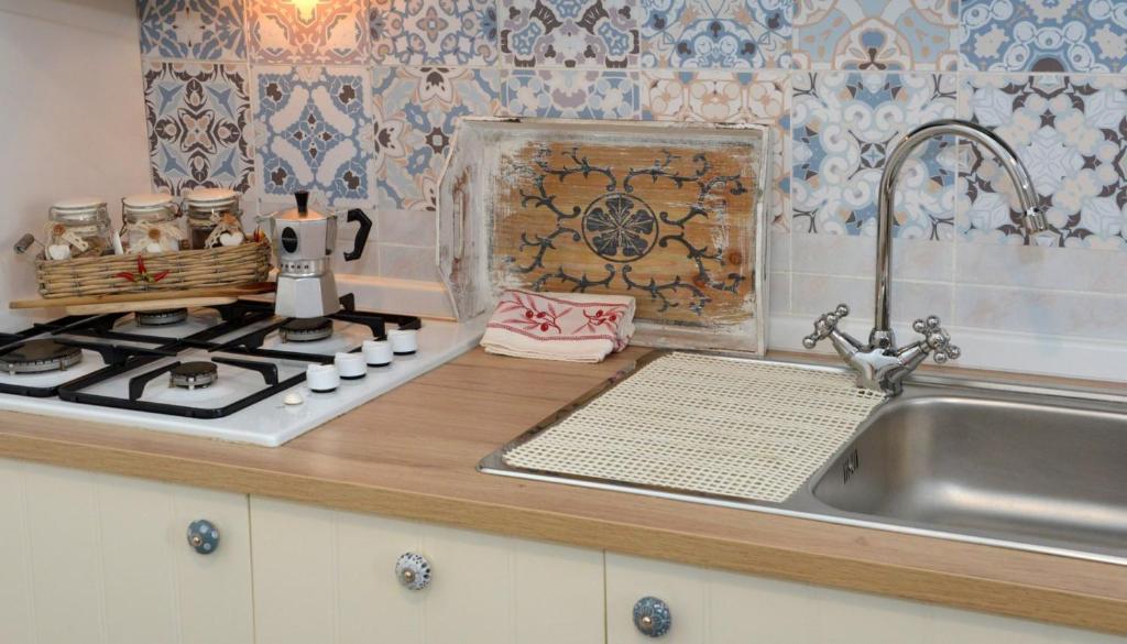 a kitchen counter with a sink and a stove at Casa Agrumeto 28 in Ostuni