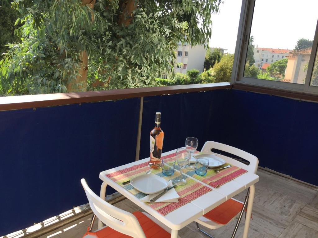 - une table avec une bouteille de vin assise sur un balcon dans l'établissement Cannes 2 pièces - Parking, à Cannes