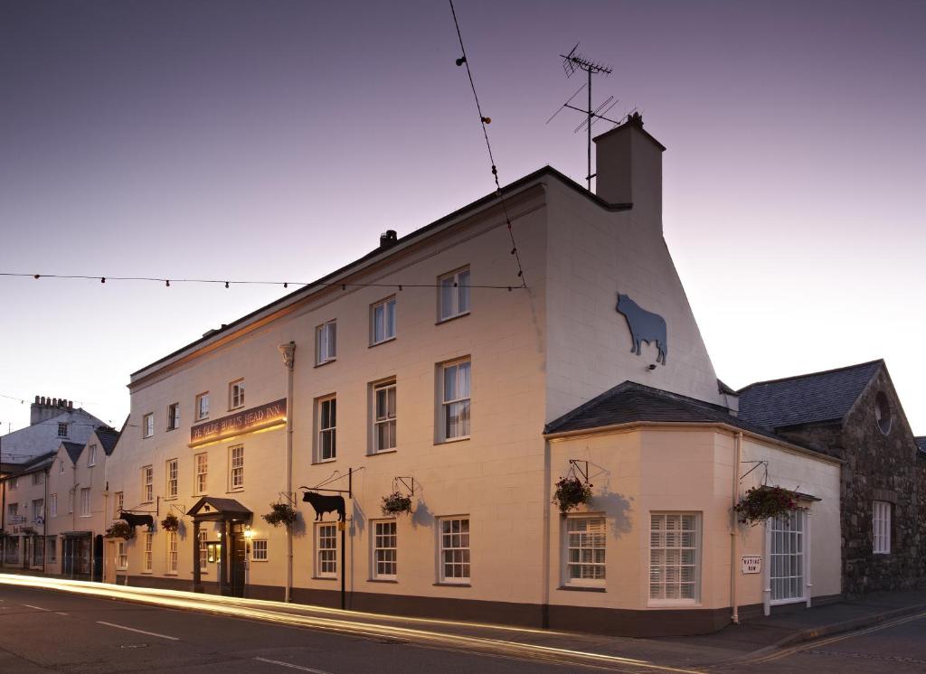 a white building with a cow on the side of it at The Bull and Townhouse - Beaumaris in Beaumaris