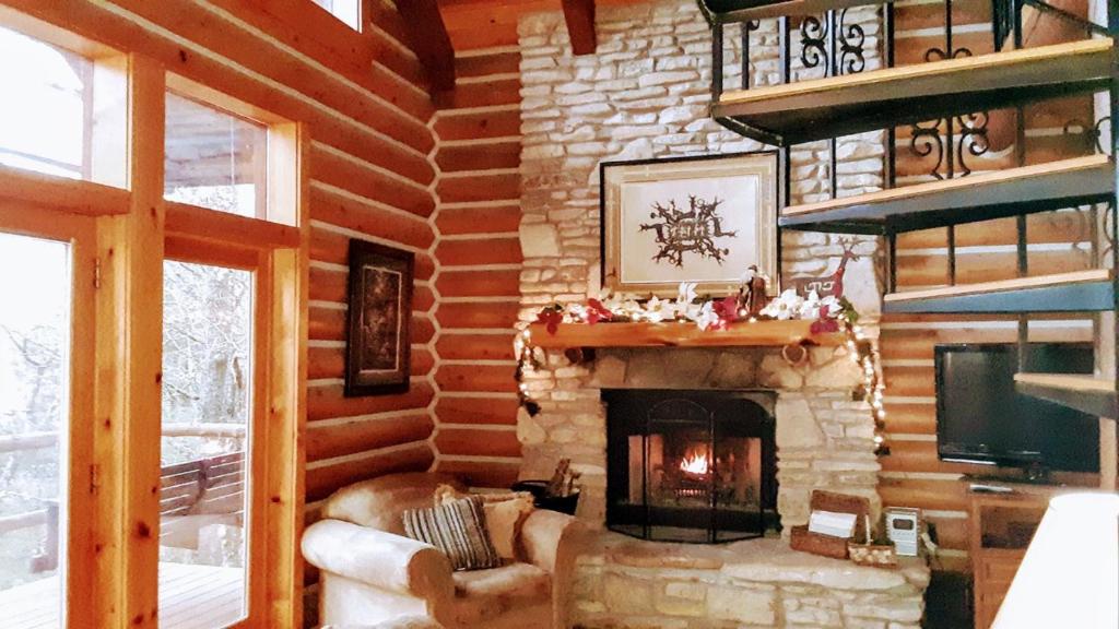a living room with a fireplace in a log cabin at Cherokee Mountain log Cabins in Eureka Springs