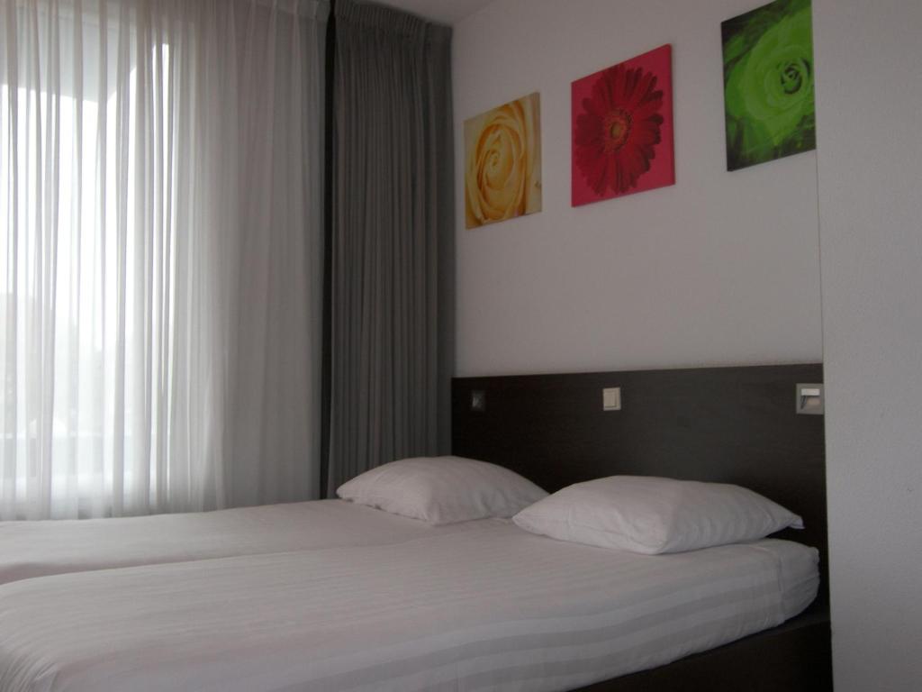 a bedroom with a bed with two pillows at Hotel de Markt in Valkenswaard