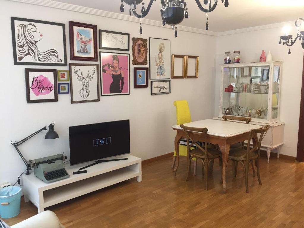 une salle à manger avec une table et une télévision dans l'établissement Casa Seines, à León