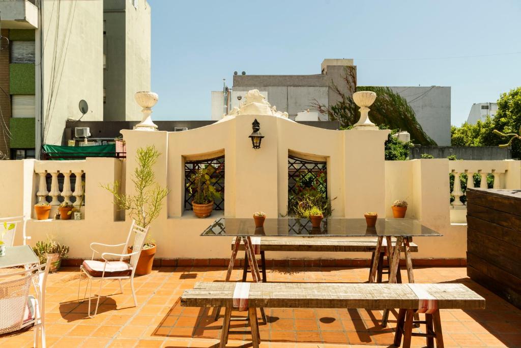 un patio avec une table et des chaises sur un toit dans l'établissement ChillHouse, à Buenos Aires