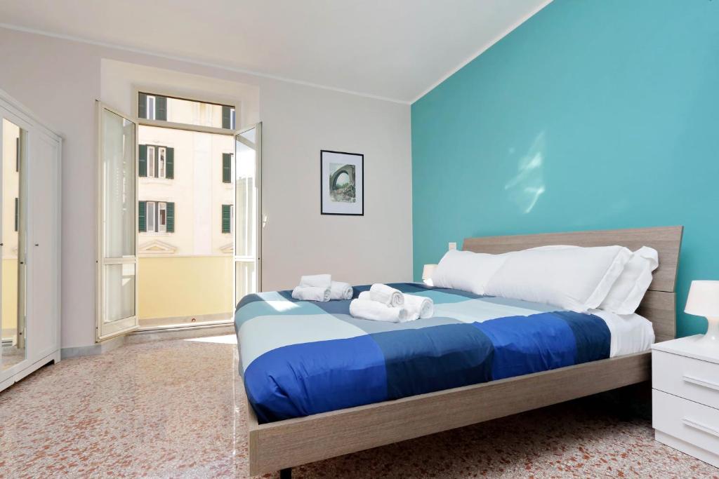 ein blaues Schlafzimmer mit einem Bett mit Handtüchern darauf in der Unterkunft WATERCOLOURS NEAR ST PETER in Rom