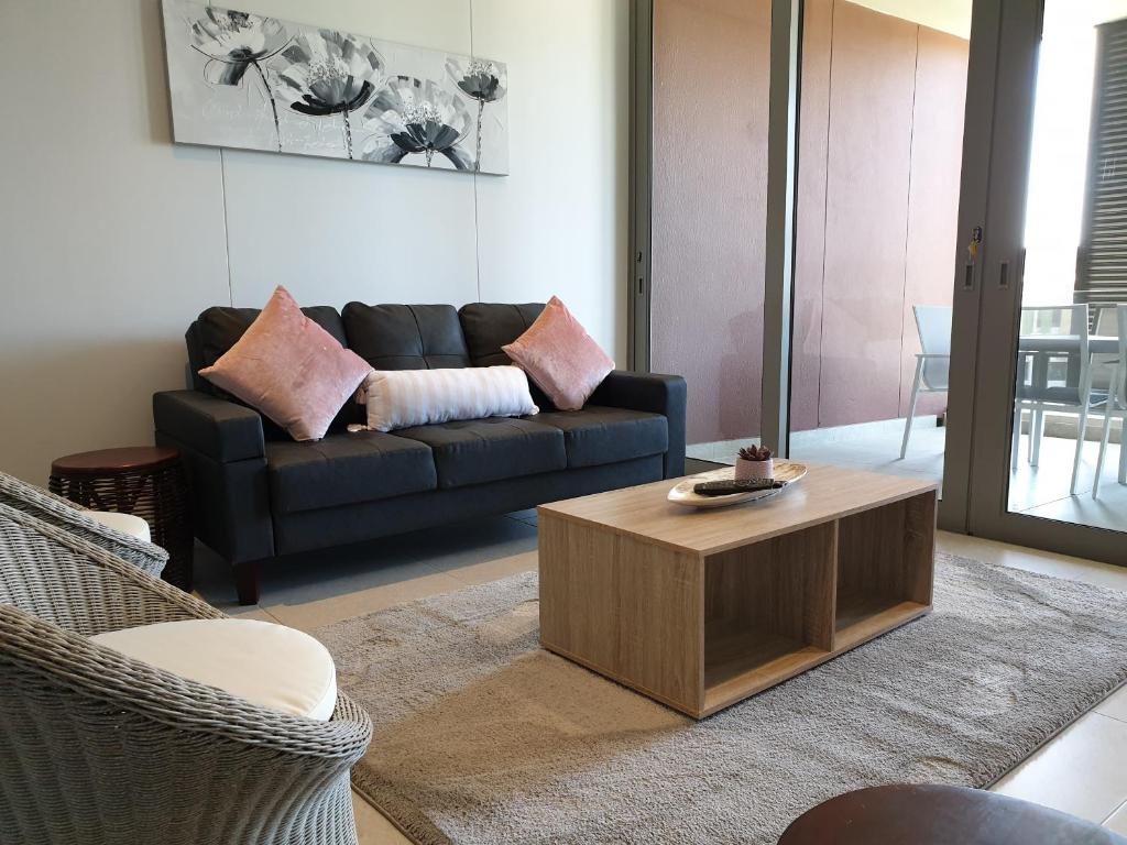 uma sala de estar com um sofá e uma mesa de centro em Ocean Dunes T428 em Durban