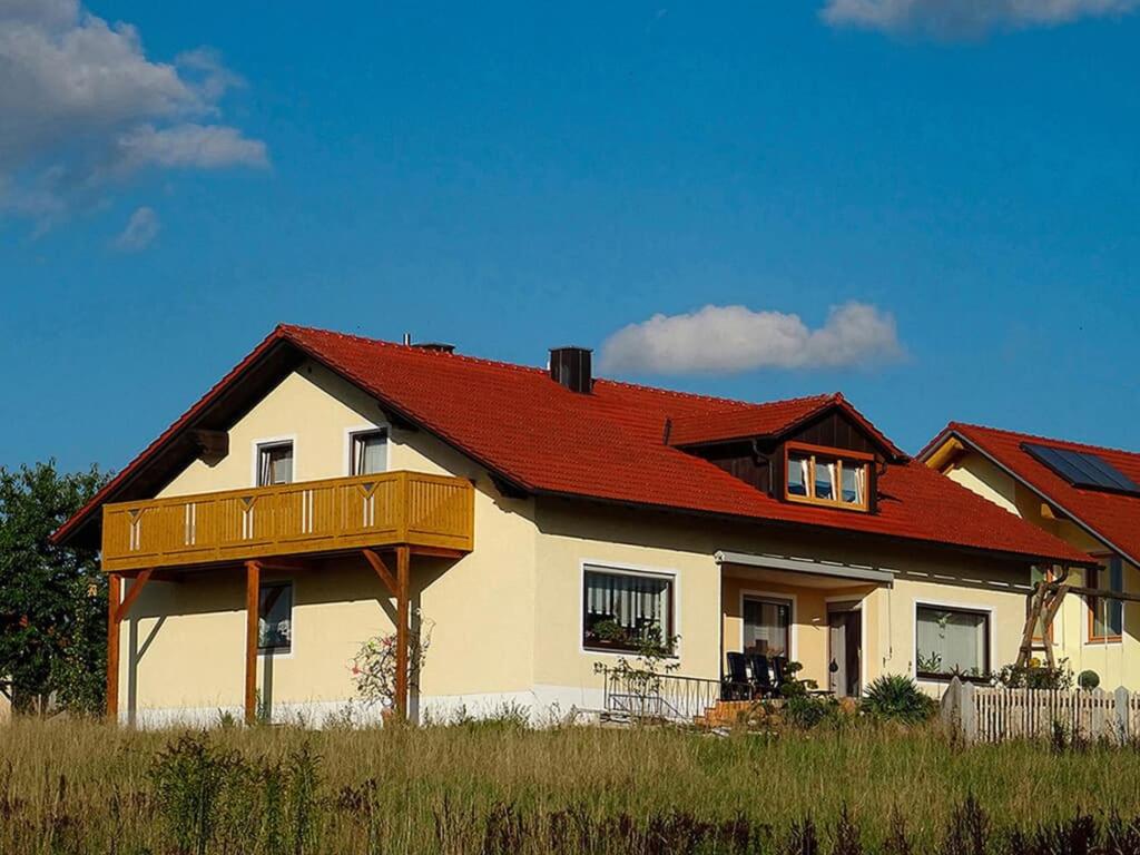 ein großes Haus mit rotem Dach in der Unterkunft Ferienwohnung Hornauer in Roding
