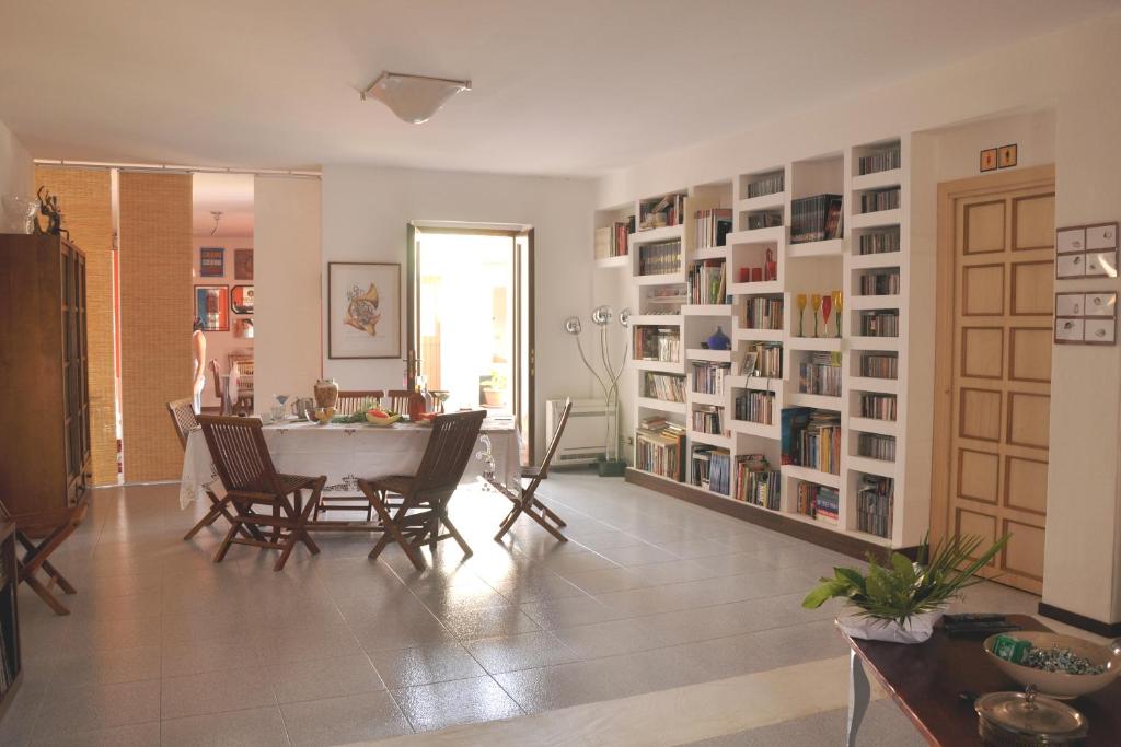 salon ze stołem, krzesłami i półkami na książki w obiekcie Lanita B&B w mieście Cabras