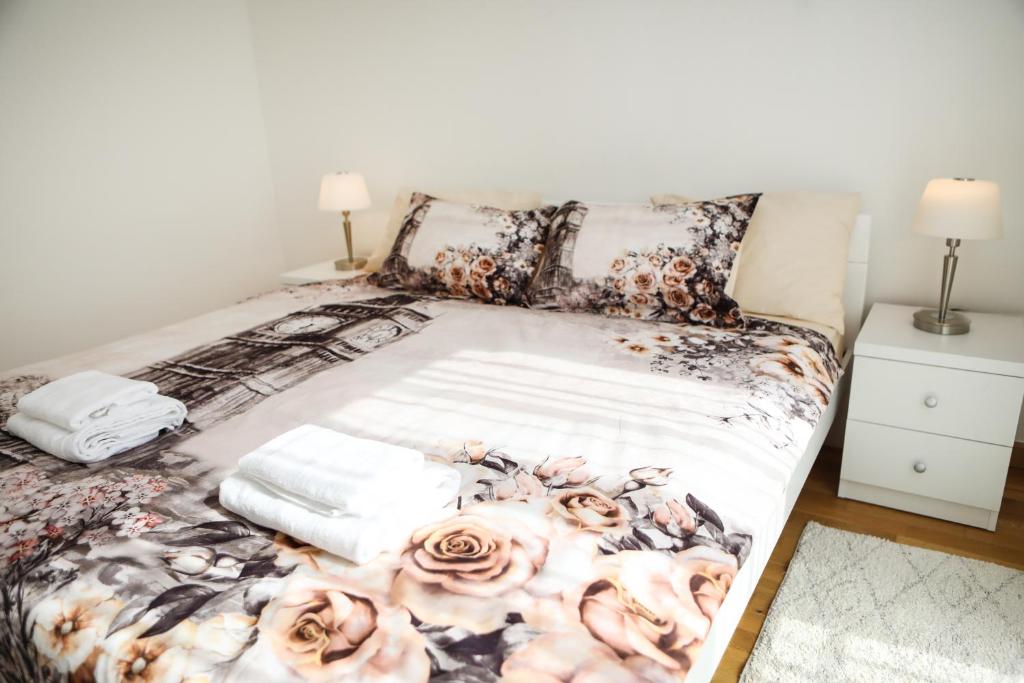 a bed with roses on it in a bedroom at Apartman Aurora in Solde