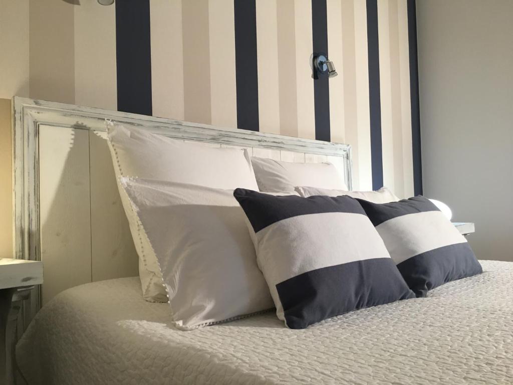 a bed with black and white pillows on it at Domaine de La Fontaine in Chavagne