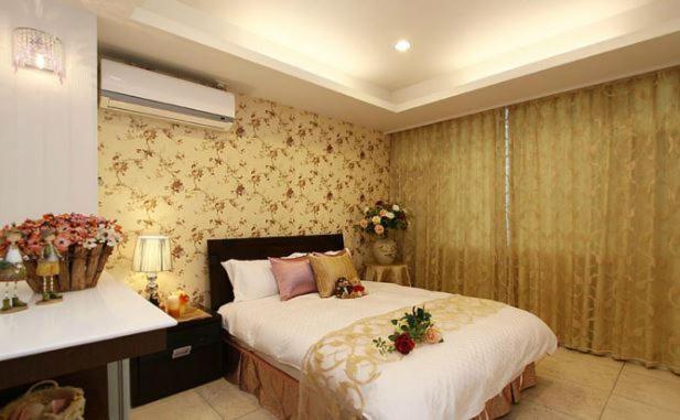 a bedroom with two beds with flowers on them at Simplicity Sojourn Hualien in Hualien City