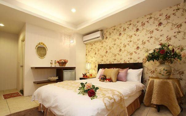 a bedroom with a large bed with flowers on it at Simplicity Sojourn Hualien in Hualien City