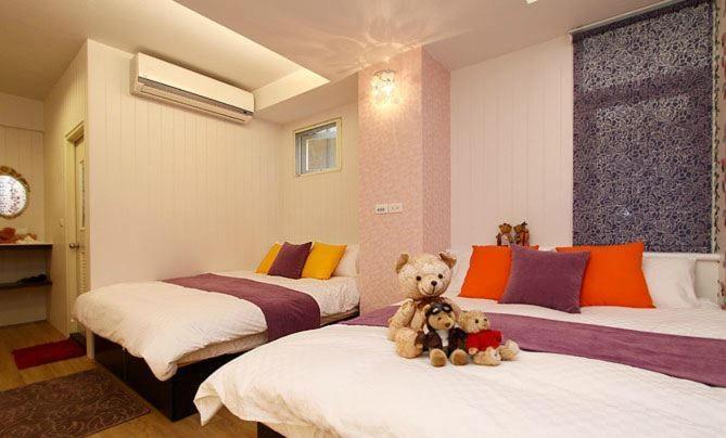 two teddy bears sitting on two beds in a room at Simplicity Sojourn Hualien in Hualien City