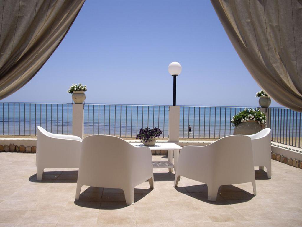 a patio with a table and chairs and a view of the ocean at Villa Punta Piccola sul mare in Porto Empedocle