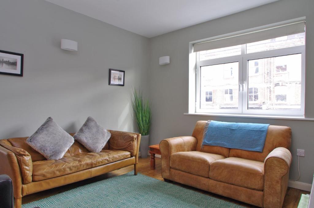 a living room with two leather chairs and a window at Comfortable Waterloo Home Near Thames in London