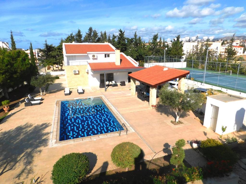 an overhead view of a swimming pool in front of a house at 6 bdr villa with TENNIS COURT in Paphos City