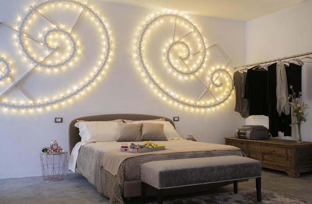 a bedroom with a bed with lights on the wall at Due Residenze da Giò in Noto