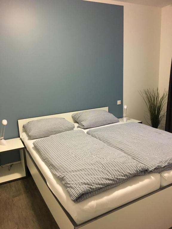 2 camas en un dormitorio con una pared azul en Boardinghouse Paderborn, en Paderborn