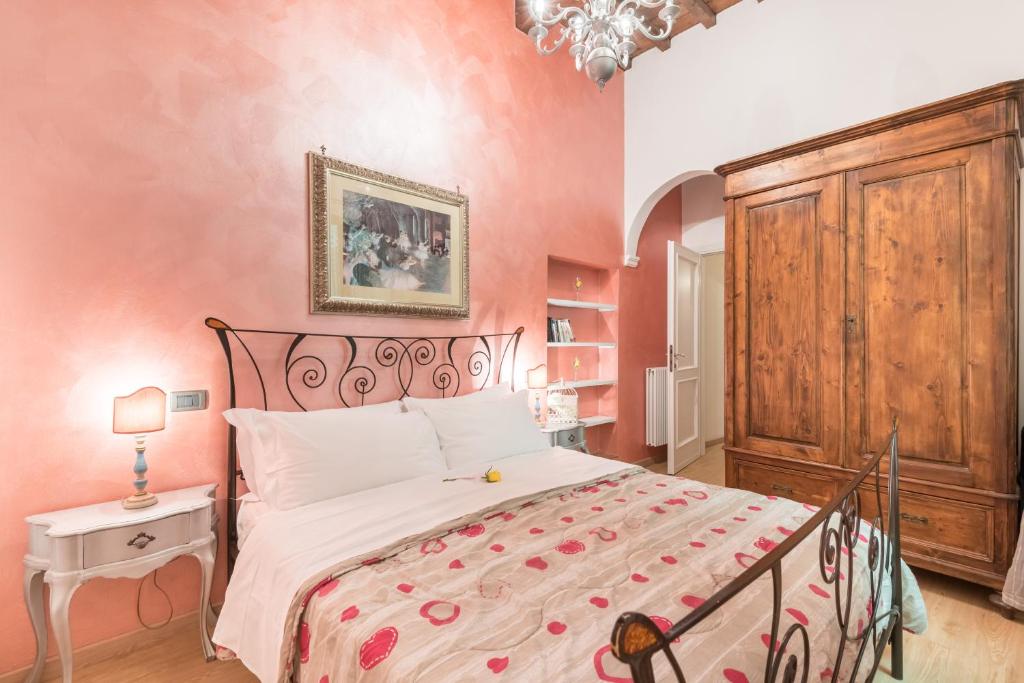 um quarto com uma cama grande e paredes cor-de-rosa em Ghibellina 22 Apartment em Florença