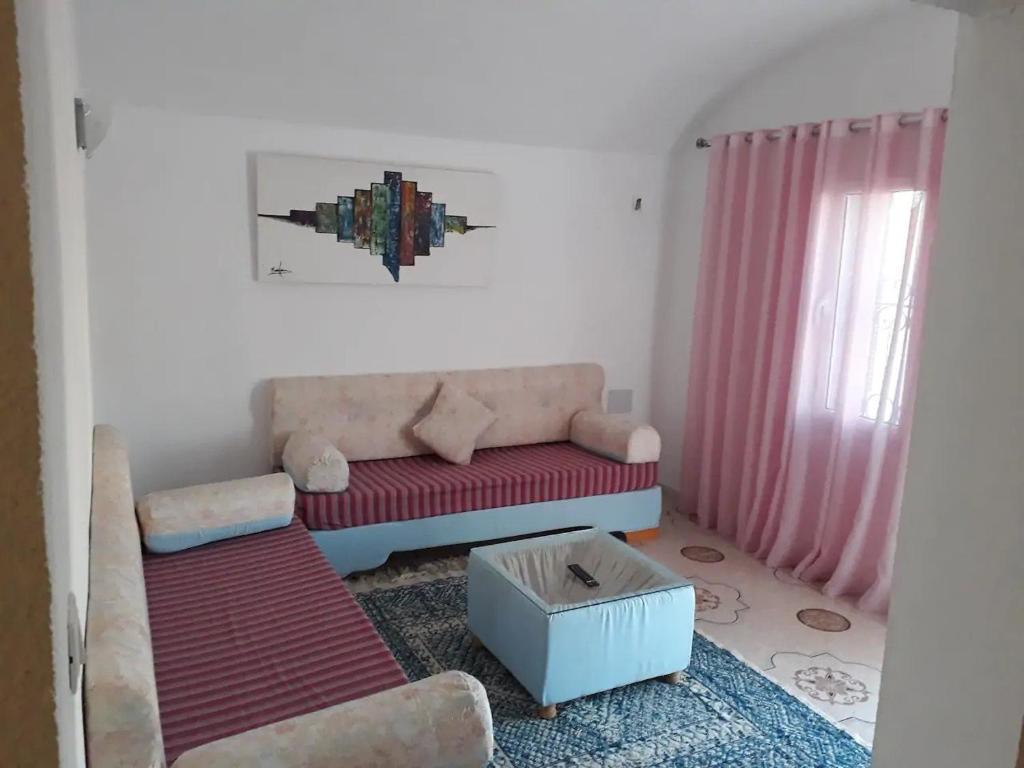 ein Wohnzimmer mit einem Sofa und einem Tisch in der Unterkunft Beltaief Residence in Houmt Souk