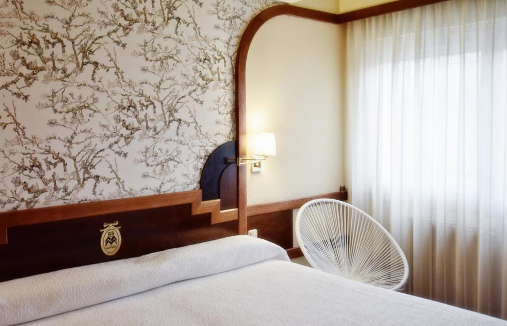 a bedroom with a white bed and a fan at Hotel Maria Luisa in Burgos