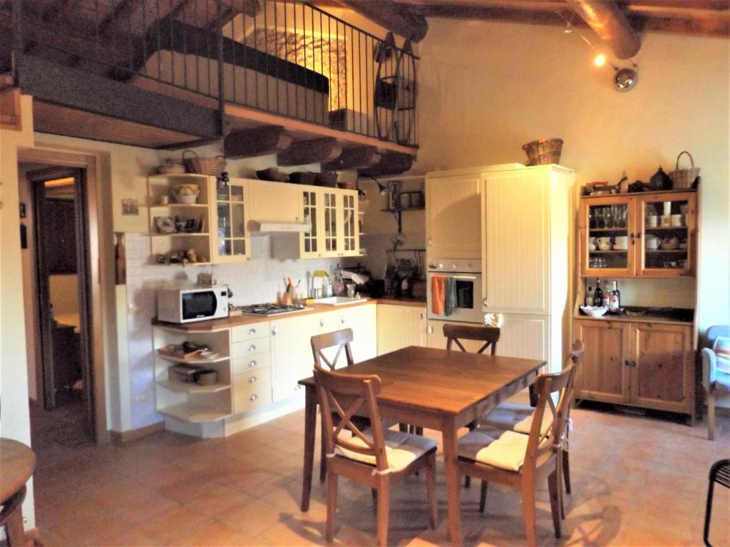 eine Küche mit einem Holztisch und Stühlen in der Unterkunft Casa Canevini in Garda