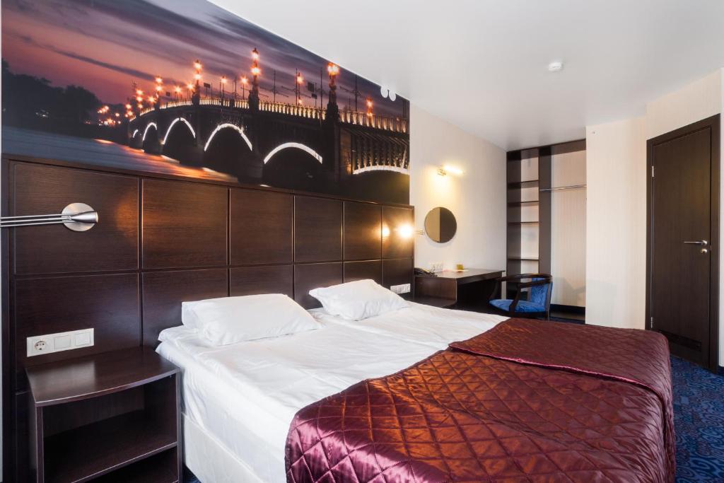 une chambre d'hôtel avec un lit et un tableau sur le mur dans l'établissement Okhtinskaya Hotel, à Saint-Pétersbourg