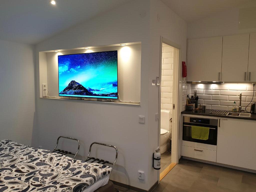 um quarto com uma cama e uma televisão na parede em PAX Apartments em Lund