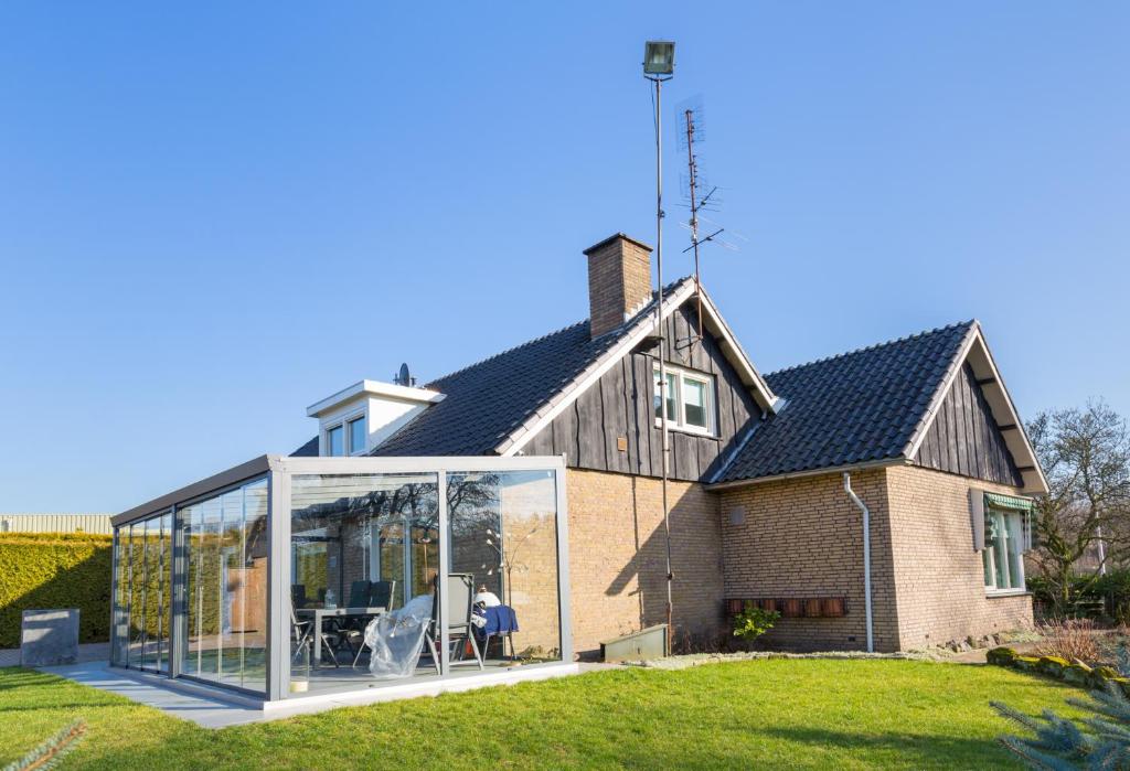 eine Erweiterung zu einem Haus mit Glastüren in der Unterkunft Bed & Breakfast Kroese in Oldenzaal