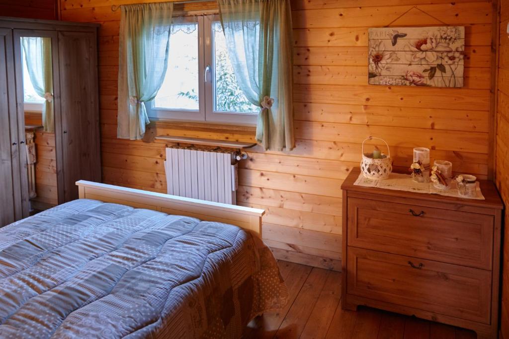 ein Schlafzimmer mit einem Bett, einer Kommode und einem Fenster in der Unterkunft piccola baita in Vigevano