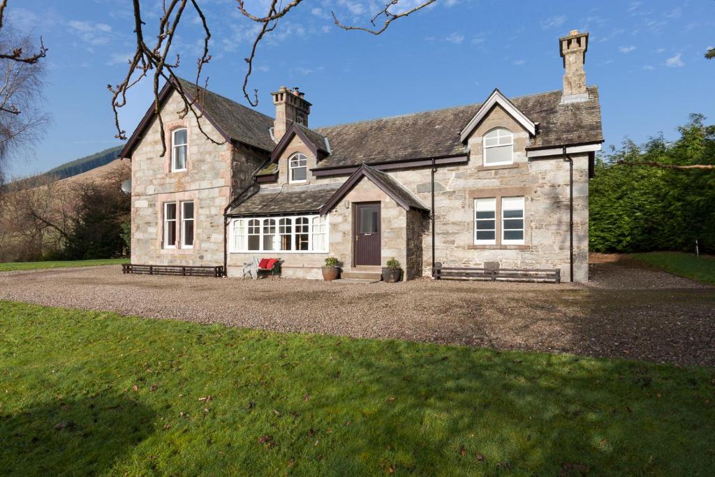 a large stone house on a gravel driveway at Ardveich House, large Scottish estate home with loch & hill views in Lochearnhead