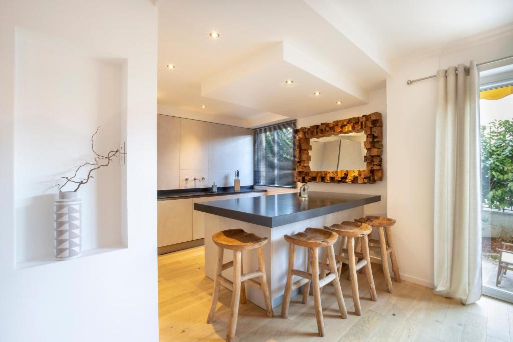 une cuisine avec un grand îlot et des tabourets dans l'établissement 3 pièces Luxe Croisette, à Cannes