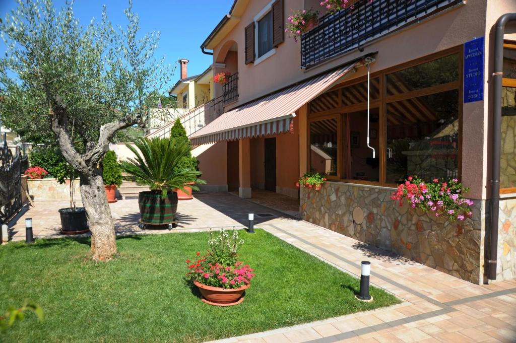 a building with plants and flowers in a yard at Casa Leona in Rovinj