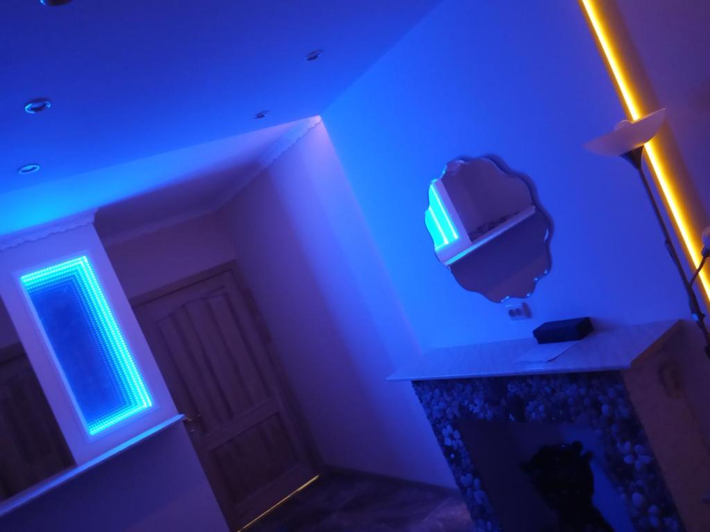 een kamer met een tv en een blauw licht bij Коломийський провулок 17/31А (1 комнатная) in Kiev