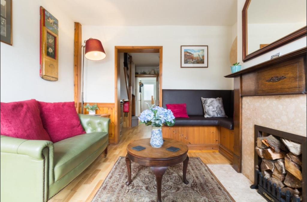 ein Wohnzimmer mit einem Sofa und einem Kamin in der Unterkunft Fergies Canal Side Cottage in Warwick