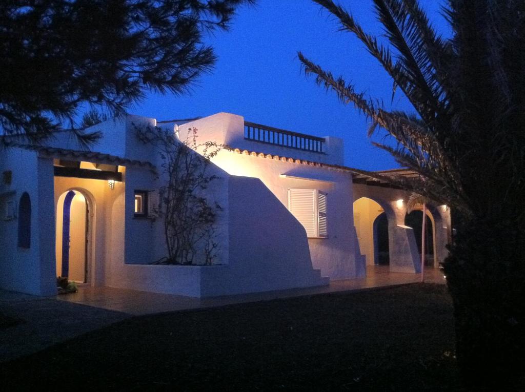 - une maison blanche avec des lumières la nuit dans l'établissement Villa Bini Roca, à Cap d'en Font