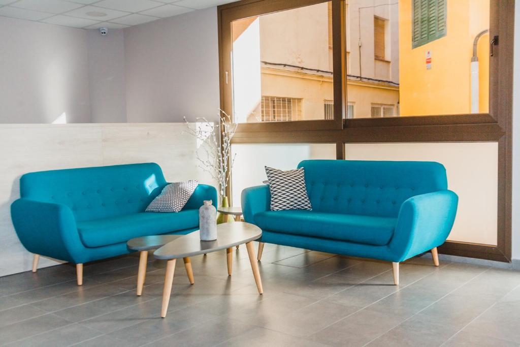 twee blauwe stoelen en een tafel in een kamer bij Solesperit in Lloret de Mar