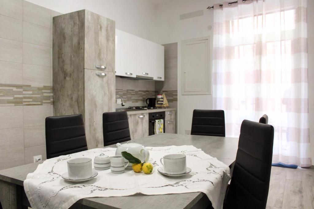 a dining room with a table and a kitchen at Case Vacanze Mare Blu in Castellammare del Golfo