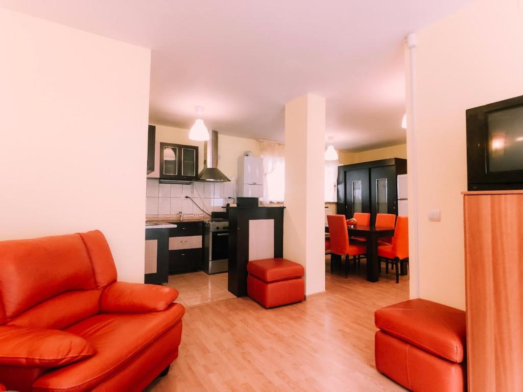 a living room with a red couch and a kitchen at Spacious Apartment near Peles in Sinaia