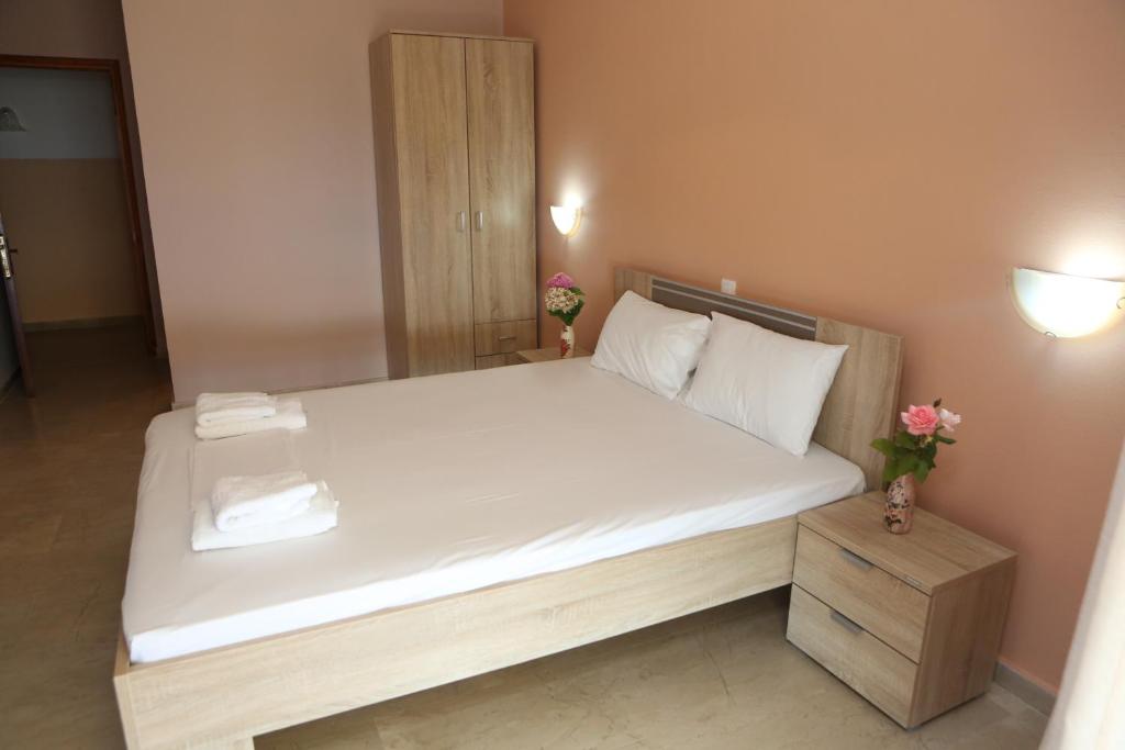 ルツァにあるSelini hotelのベッドルーム1室(大型ベッド1台、白いシーツ、枕付)