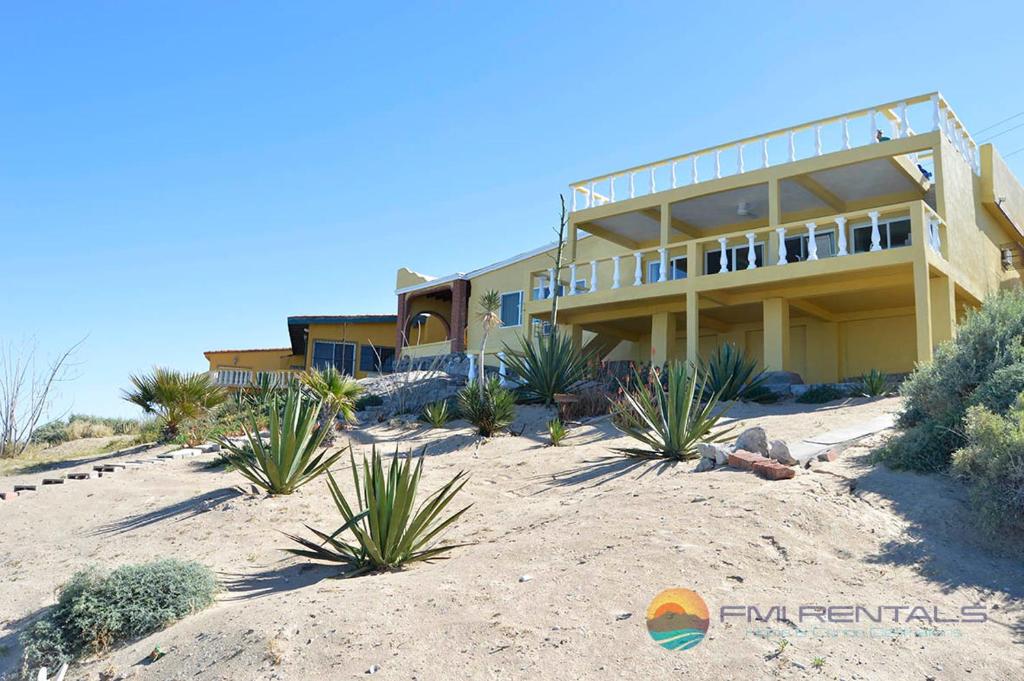 a house on the beach with plants in front of it at Casa Pelicano in Puerto Peñasco