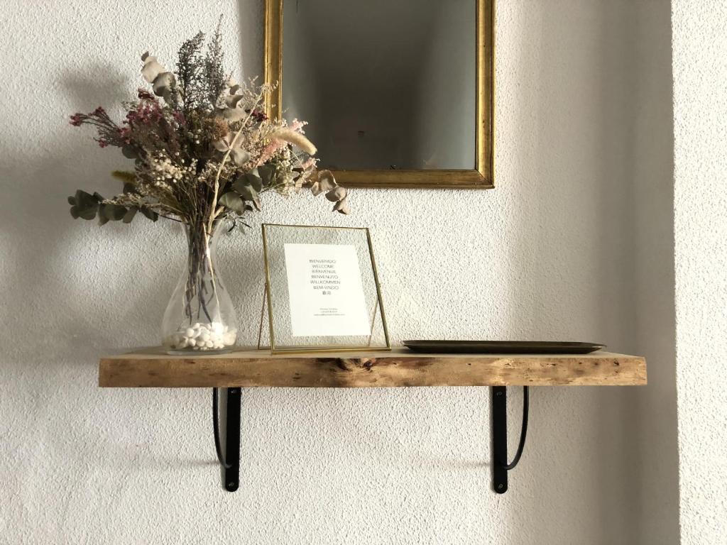 une table avec un vase de fleurs et un livre dans l'établissement Apartamento Homies Córdoba, à Cordoue