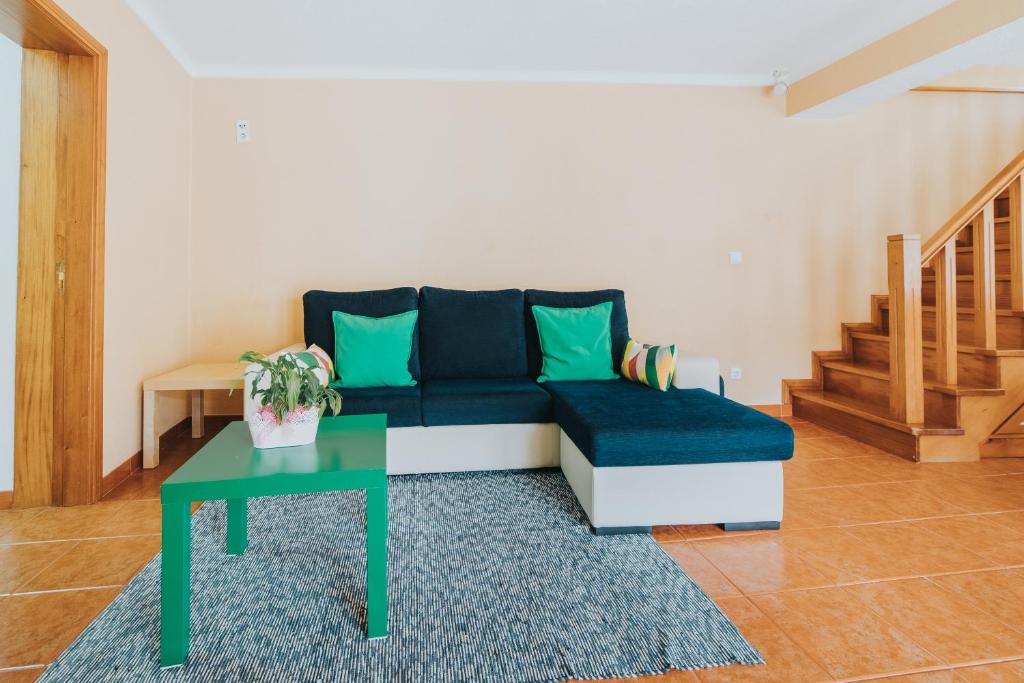 un soggiorno con divano blu e tavolo di Silver Coast House until 7 Guests a Seixo