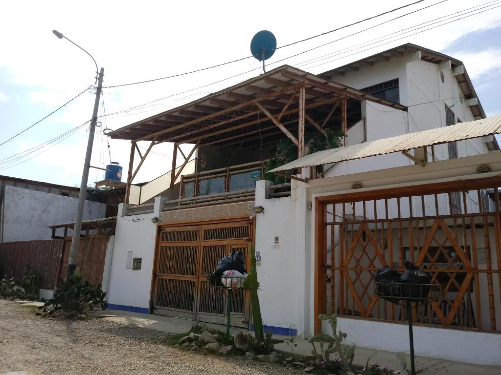 una casa blanca con una puerta y un edificio en Los Pinos de Zorritos Condominio, en Zorritos