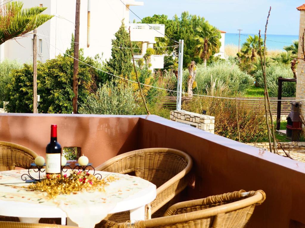 un tavolo con una bottiglia di vino su un balcone di Casa di kampos ad Adelianos Kampos