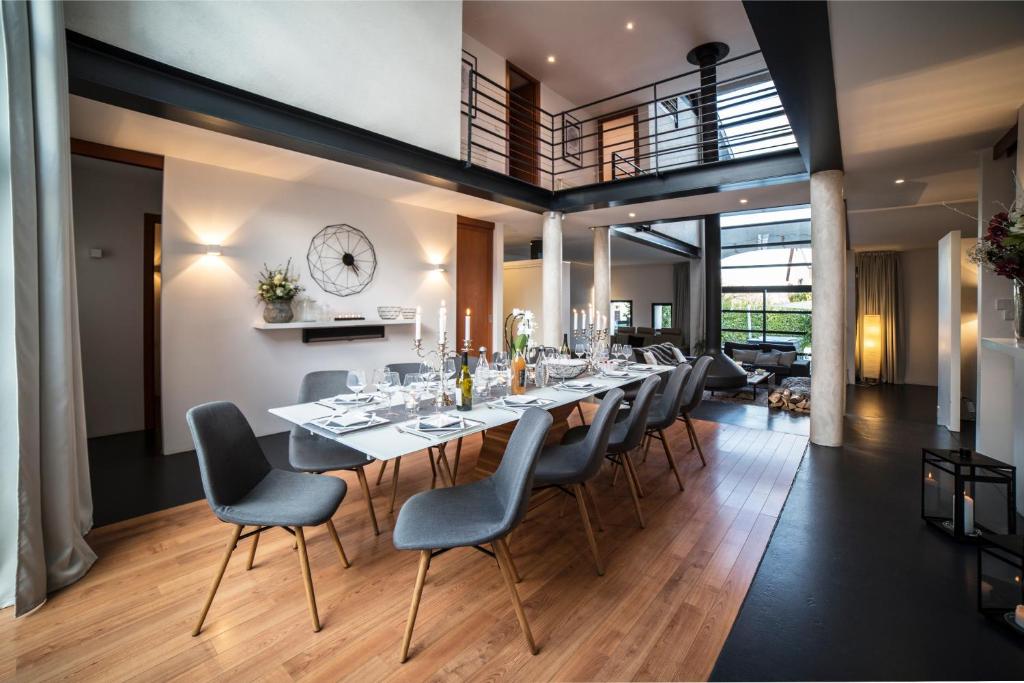 a dining room with a long table and chairs at La Grange Emnitan - Grande maison 12 pers avec jacuzzi proche Genève in Saint-Genis-Pouilly