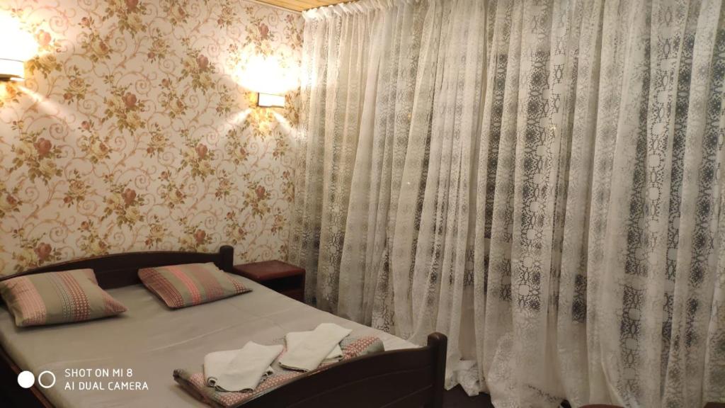 a bedroom with a bed and a curtain with towels on it at Maza Kalna 27 in Rīga