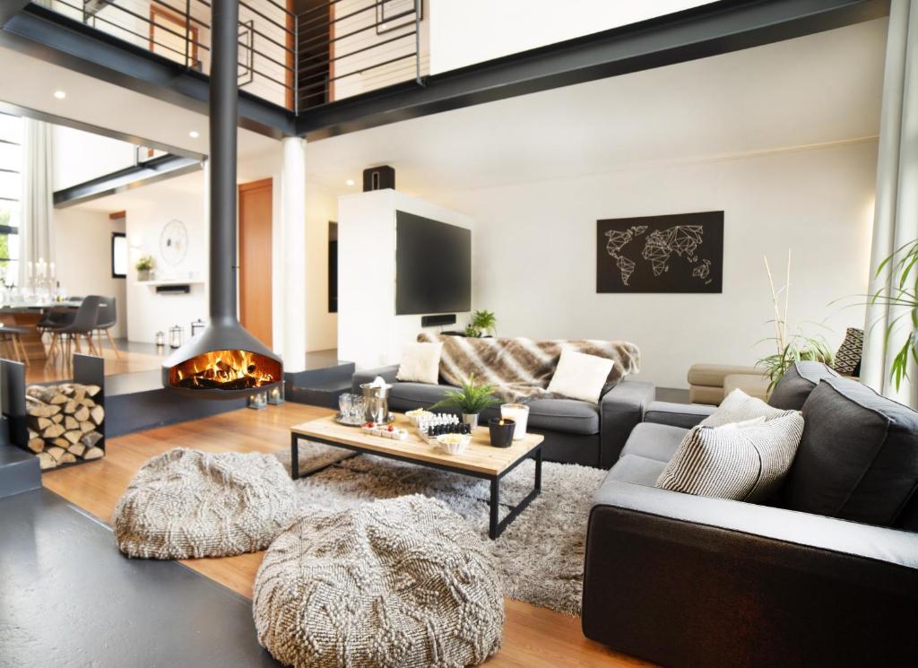 ein Wohnzimmer mit einem Sofa und einem Kamin in der Unterkunft La Grange Emnitan - Maison de ville moderne pour 12p Fêtes interdites in Saint-Genis-Pouilly
